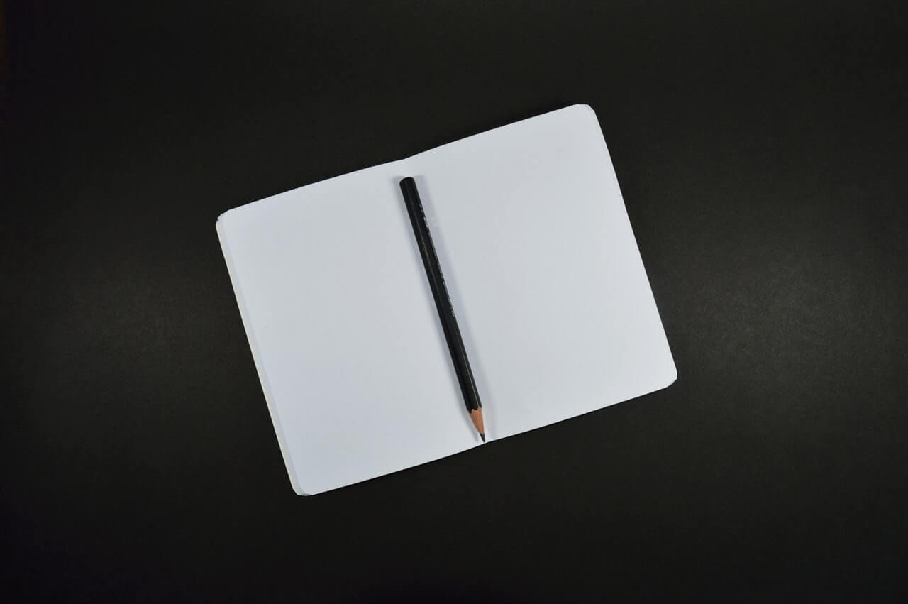 A pencil resting on a blank notebook